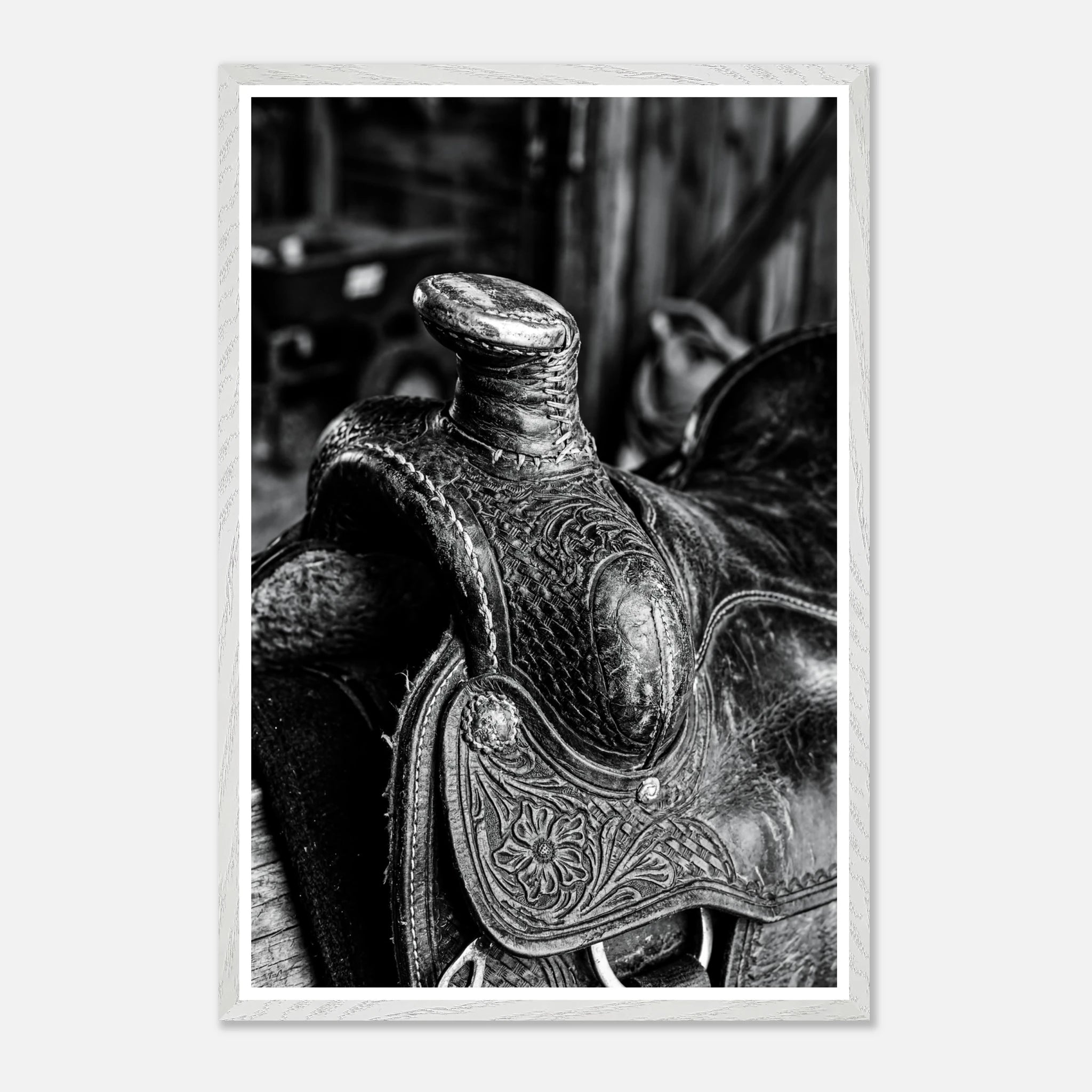 Black and white close up of a western saddle with worn leather and detailed craftsmanship, ranch wall art.