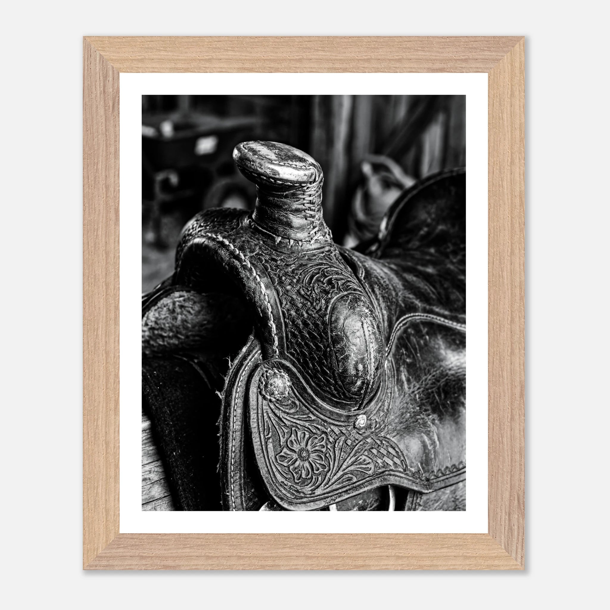Black and white close up of a western saddle with worn leather and detailed craftsmanship, ranch wall art.