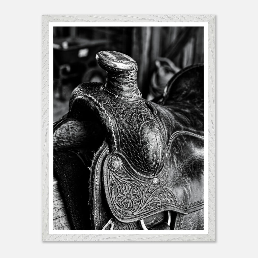 Black and white close up of a western saddle with worn leather and detailed craftsmanship, ranch wall art.