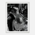 Black and white close up of a western saddle with worn leather and detailed craftsmanship, ranch wall art.
