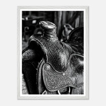 Black and white close up of a western saddle with worn leather and detailed craftsmanship, ranch wall art.