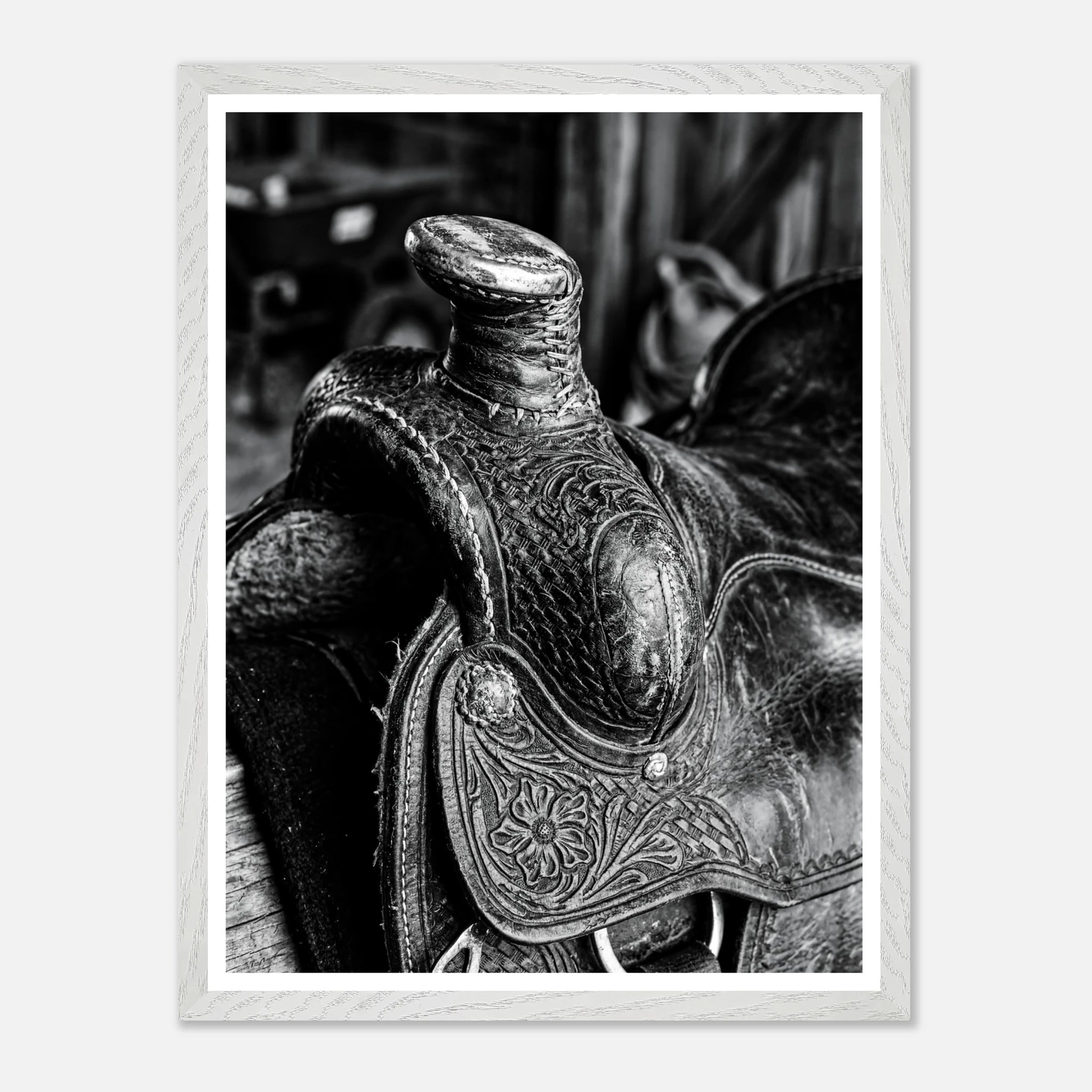 Black and white close up of a western saddle with worn leather and detailed craftsmanship, ranch wall art.