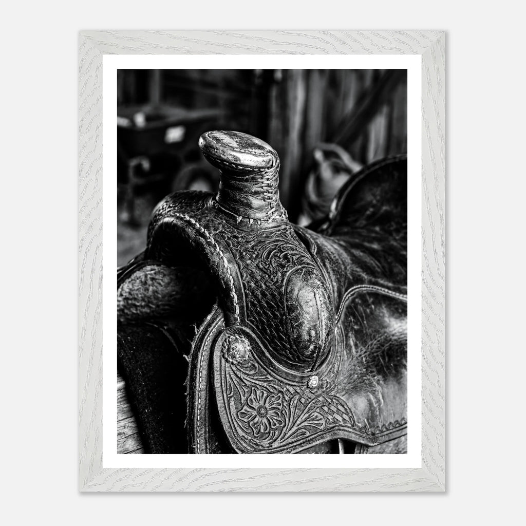 Black and white close up of a western saddle with worn leather and detailed craftsmanship, ranch wall art.