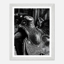 Black and white close up of a western saddle with worn leather and detailed craftsmanship, ranch wall art.
