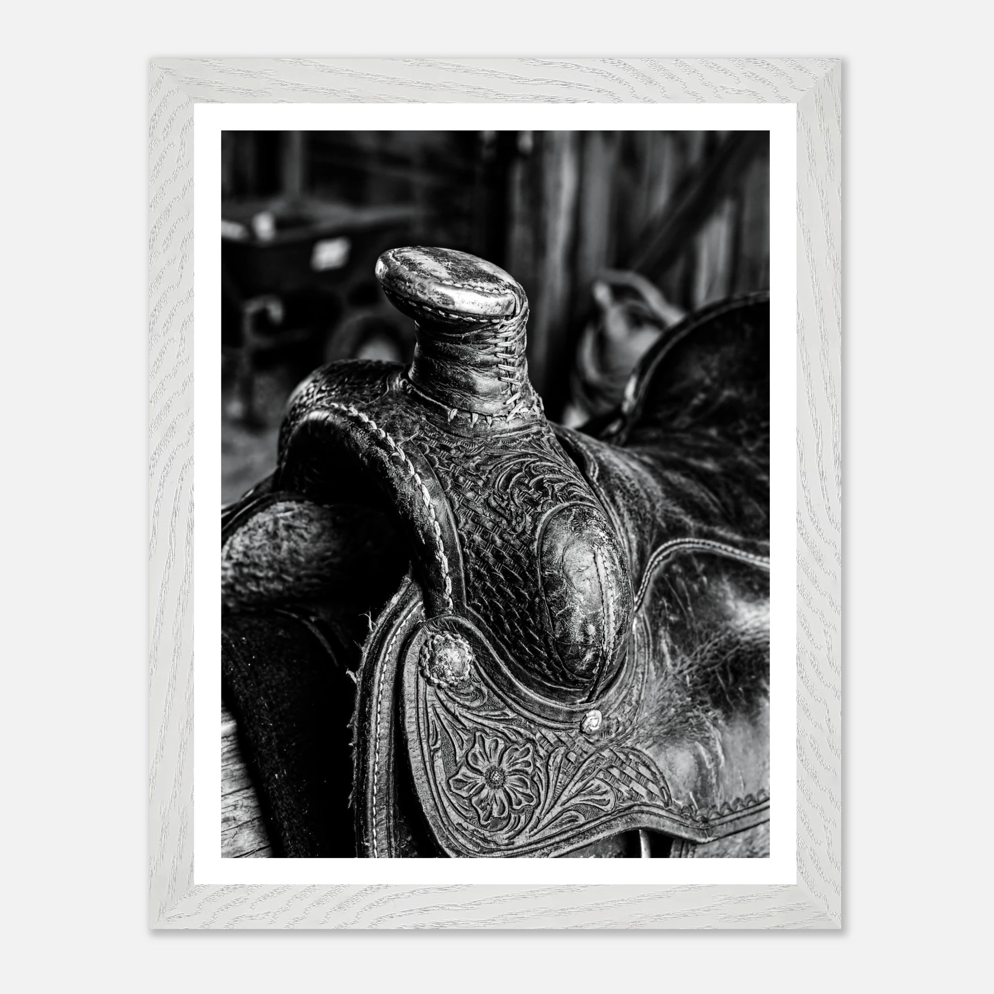 Black and white close up of a western saddle with worn leather and detailed craftsmanship, ranch wall art.