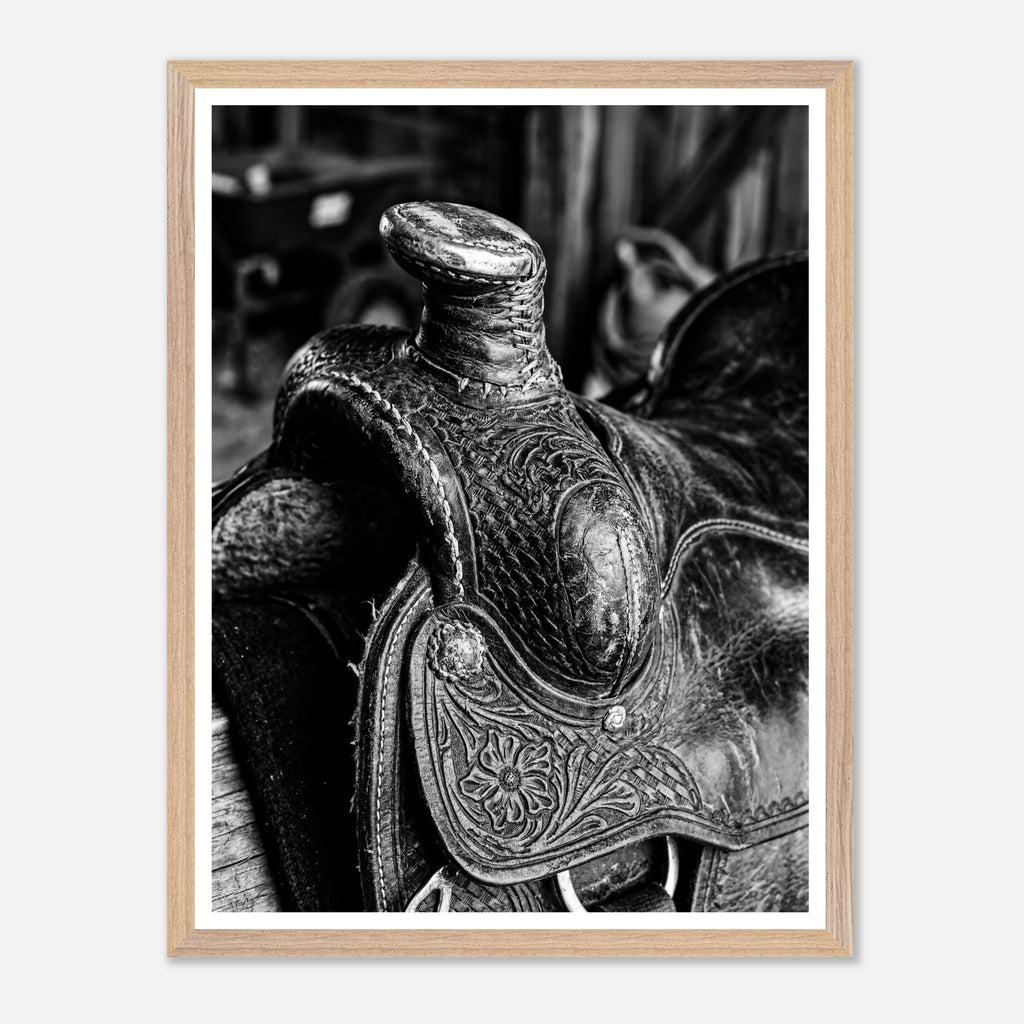 Black and white close up of a western saddle with worn leather and detailed craftsmanship, ranch wall art.