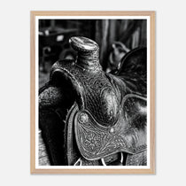 Black and white close up of a western saddle with worn leather and detailed craftsmanship, ranch wall art.
