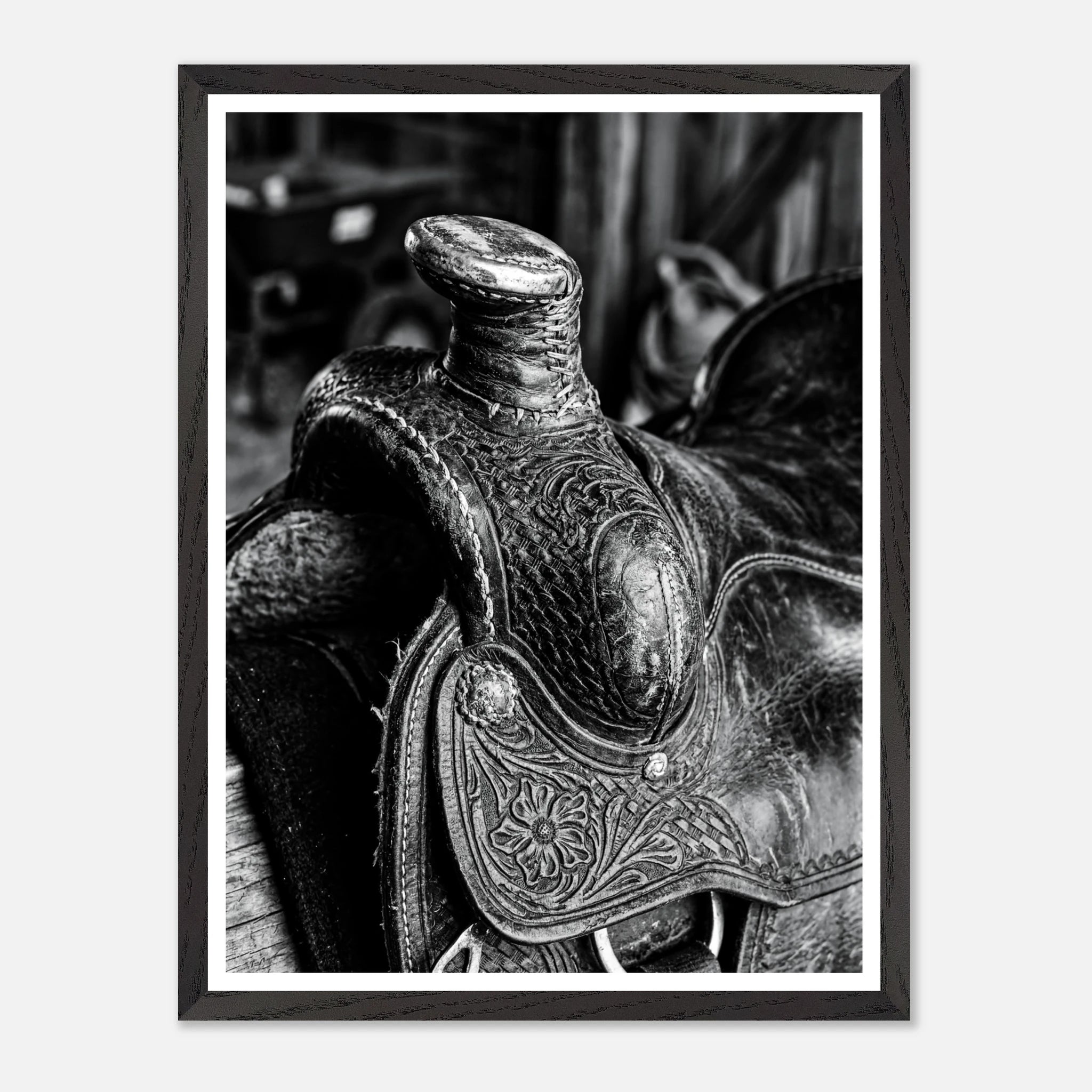 Black and white close up of a western saddle with worn leather and detailed craftsmanship, ranch wall art.
