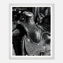 Black and white close up of a western saddle with worn leather and detailed craftsmanship, ranch wall art.