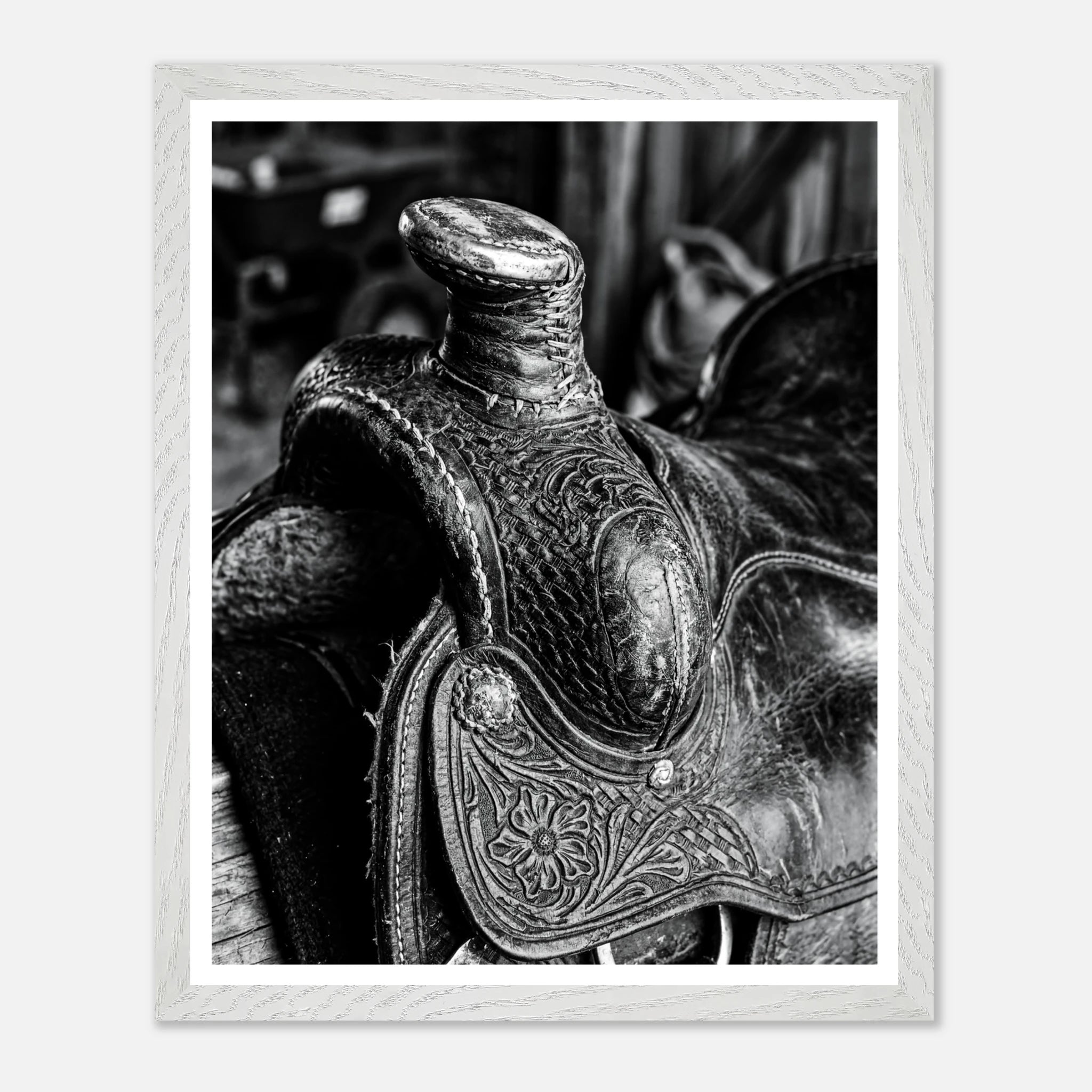 Black and white close up of a western saddle with worn leather and detailed craftsmanship, ranch wall art.