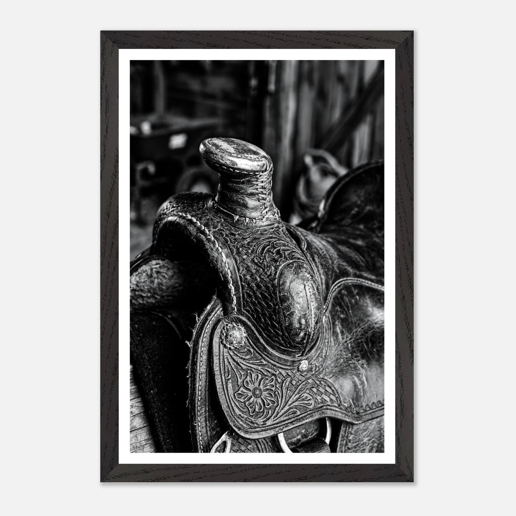 Black and white close up of a western saddle with worn leather and detailed craftsmanship, ranch wall art.