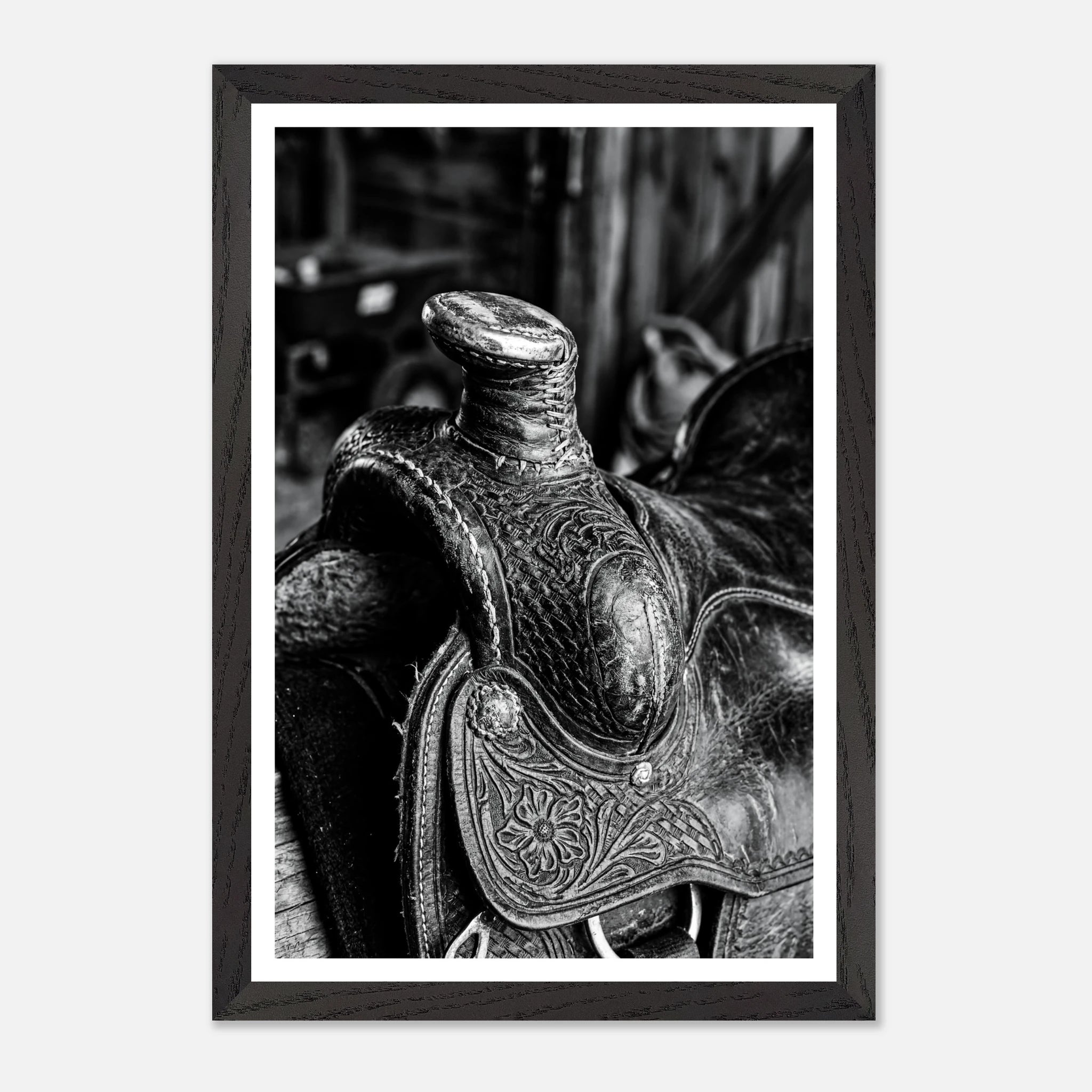Black and white close up of a western saddle with worn leather and detailed craftsmanship, ranch wall art.