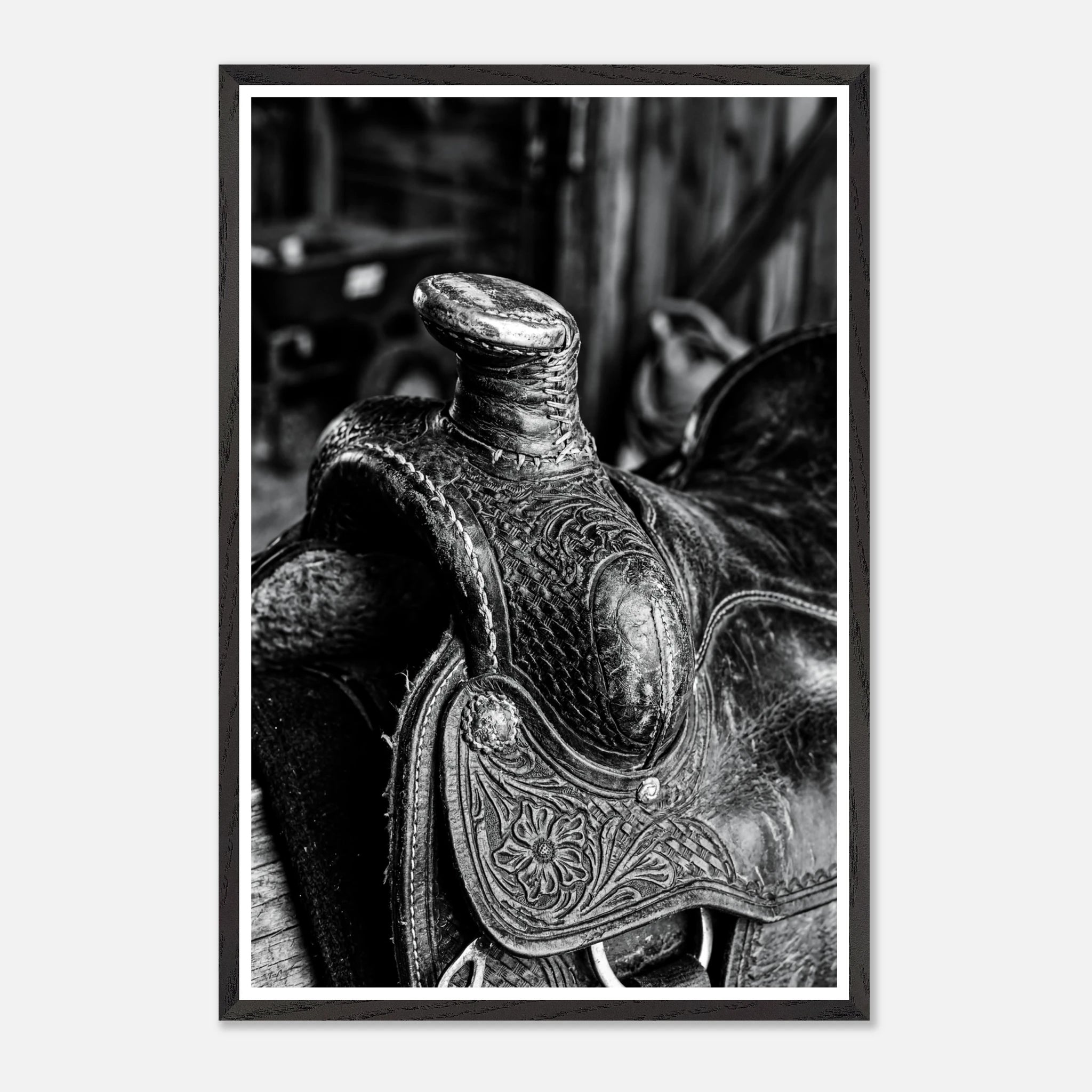 Black and white close up of a western saddle with worn leather and detailed craftsmanship, ranch wall art.