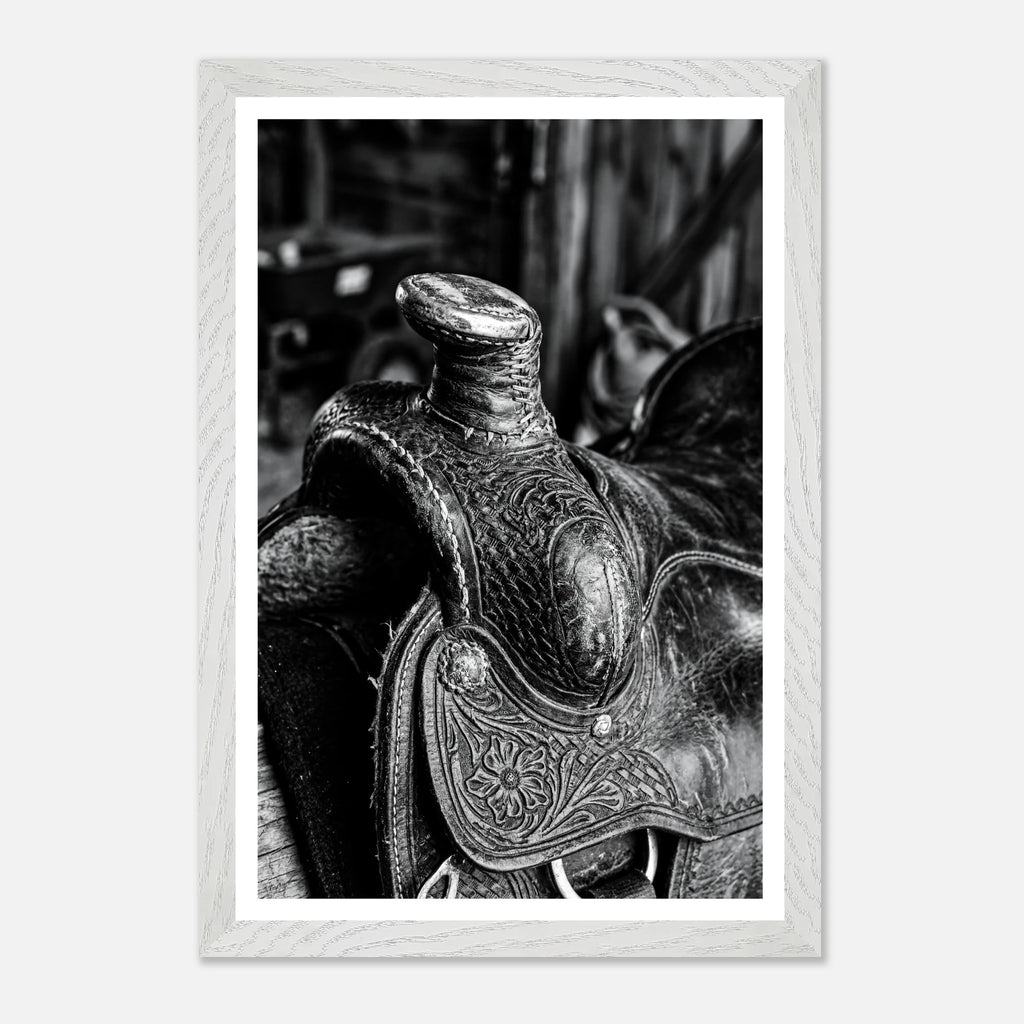 Black and white close up of a western saddle with worn leather and detailed craftsmanship, ranch wall art.