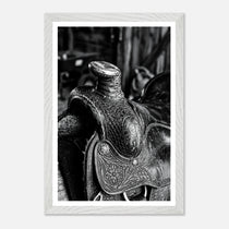 Black and white close up of a western saddle with worn leather and detailed craftsmanship, ranch wall art.