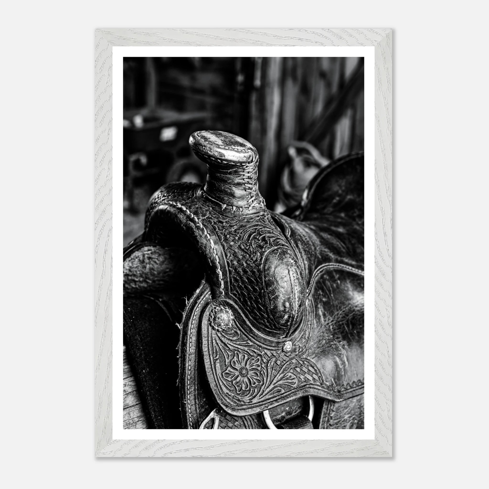 Black and white close up of a western saddle with worn leather and detailed craftsmanship, ranch wall art.