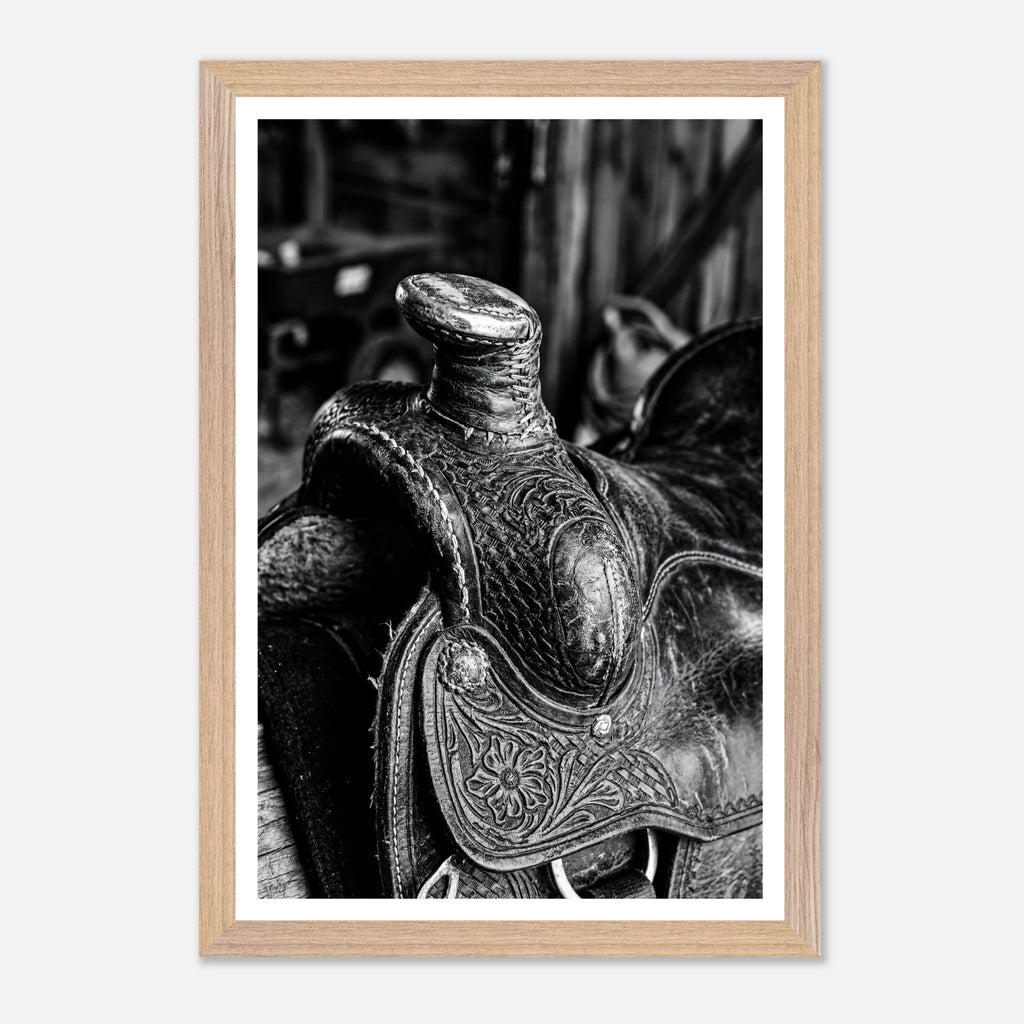 Black and white close up of a western saddle with worn leather and detailed craftsmanship, ranch wall art.