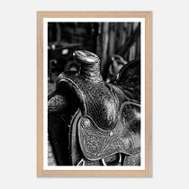 Black and white close up of a western saddle with worn leather and detailed craftsmanship, ranch wall art.