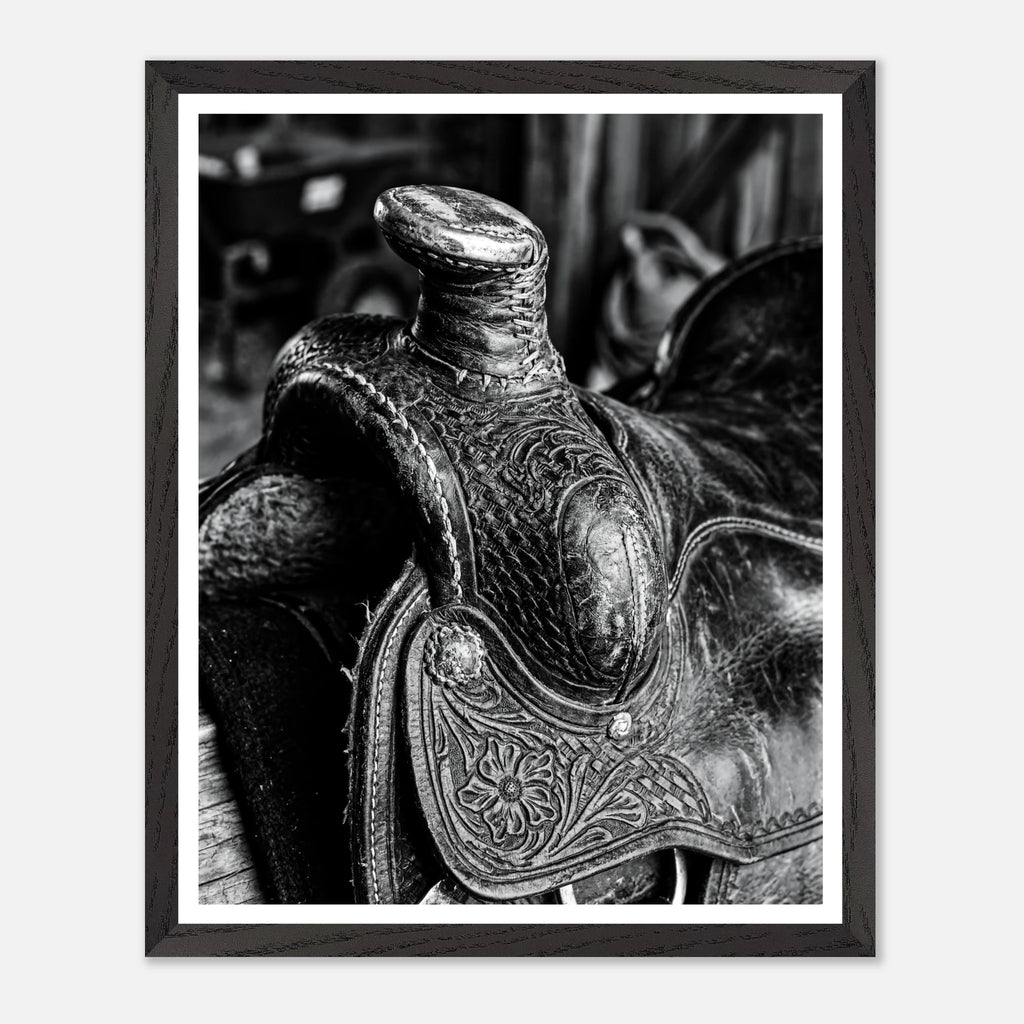 Black and white close up of a western saddle with worn leather and detailed craftsmanship, ranch wall art.