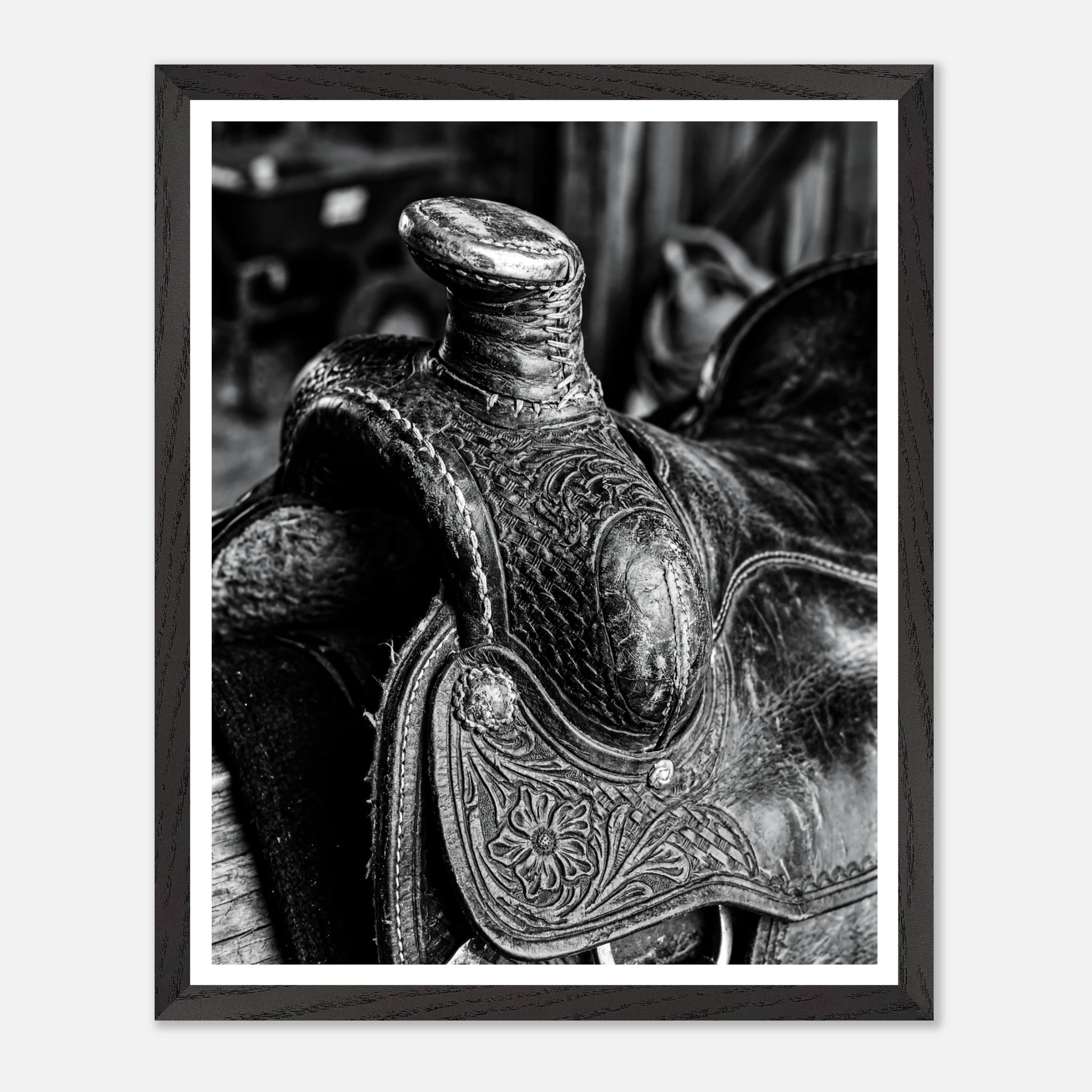 Black and white close up of a western saddle with worn leather and detailed craftsmanship, ranch wall art.