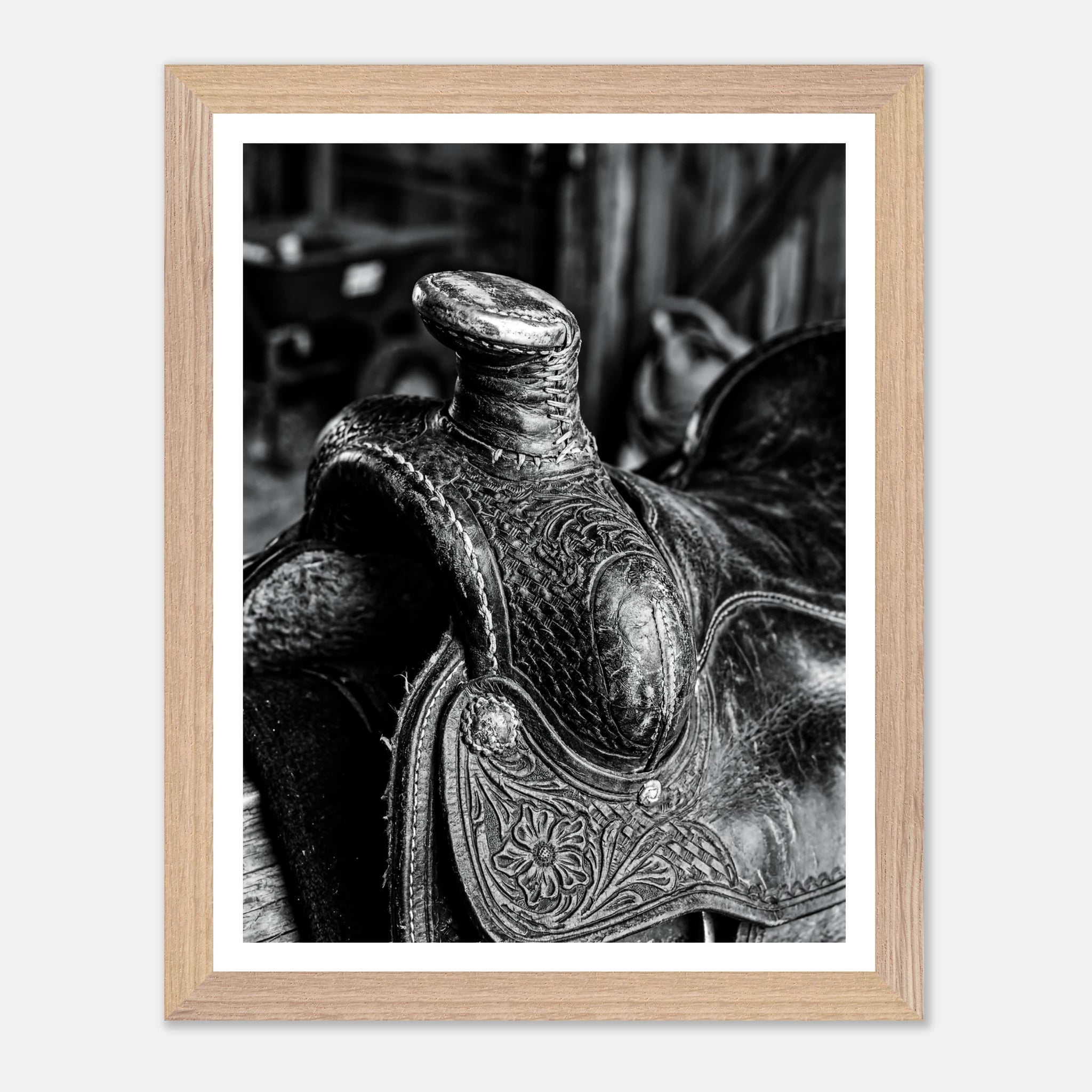 Black and white close up of a western saddle with worn leather and detailed craftsmanship, ranch wall art.