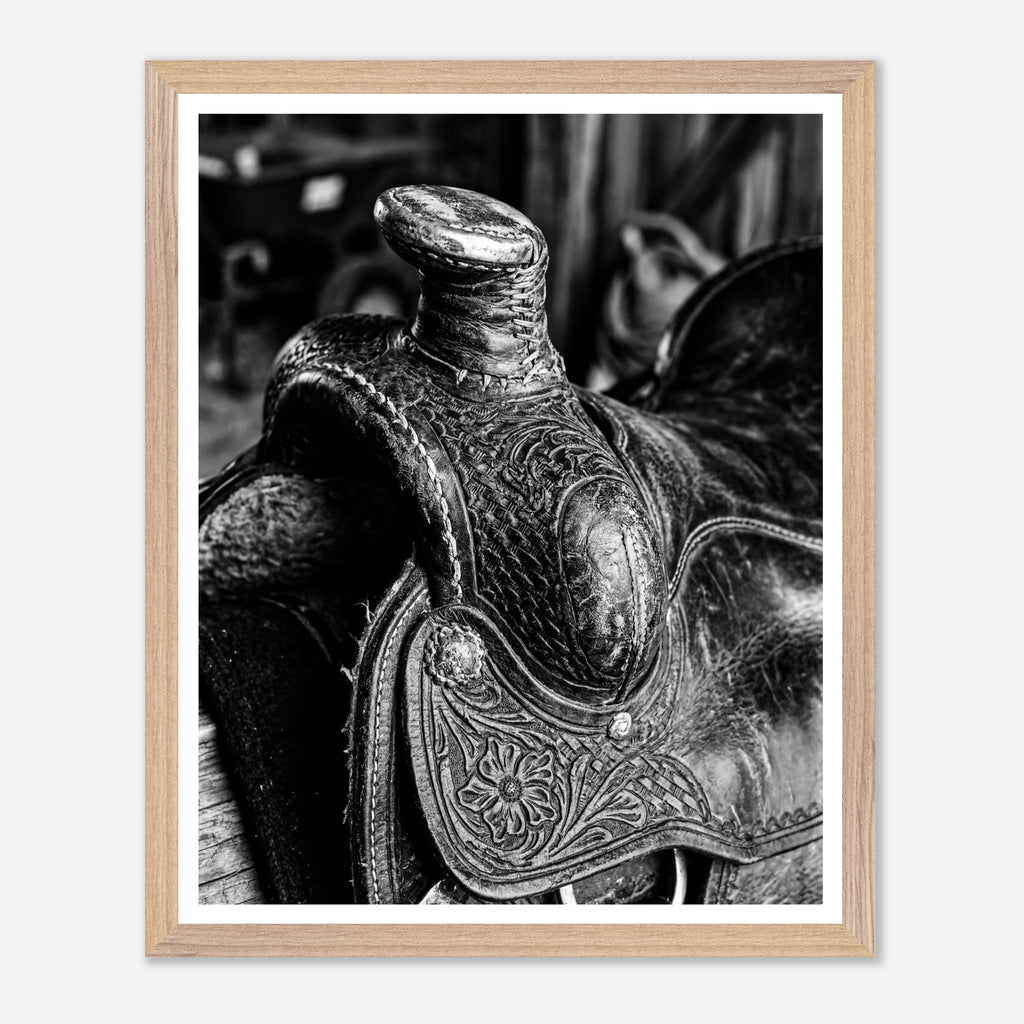 Black and white close up of a western saddle with worn leather and detailed craftsmanship, ranch wall art.