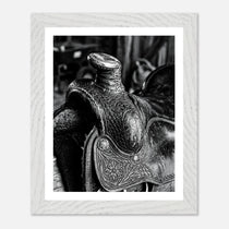 Black and white close up of a western saddle with worn leather and detailed craftsmanship, ranch wall art.
