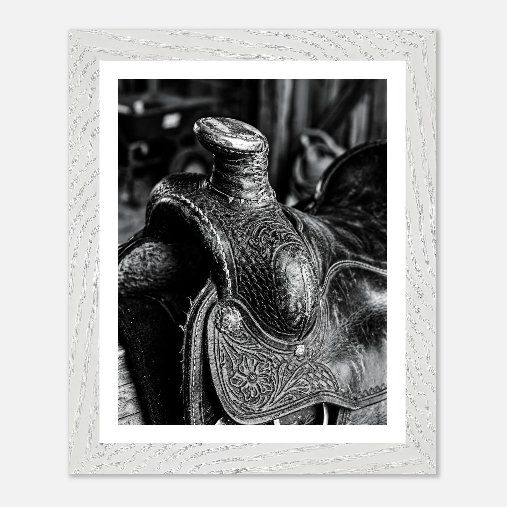 Black and white close up of a western saddle with worn leather and detailed craftsmanship, ranch wall art.