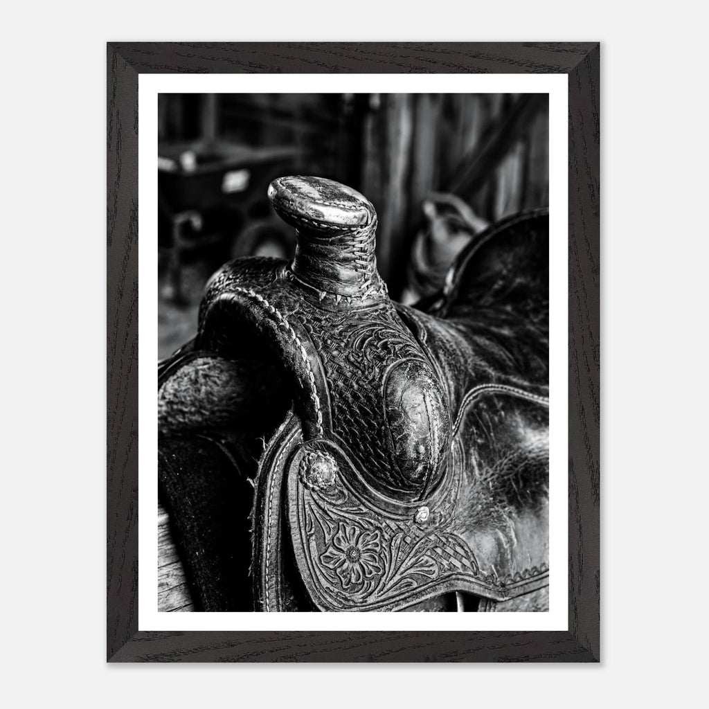 Black and white close up of a western saddle with worn leather and detailed craftsmanship, ranch wall art.