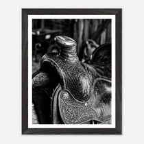 Black and white close up of a western saddle with worn leather and detailed craftsmanship, ranch wall art.