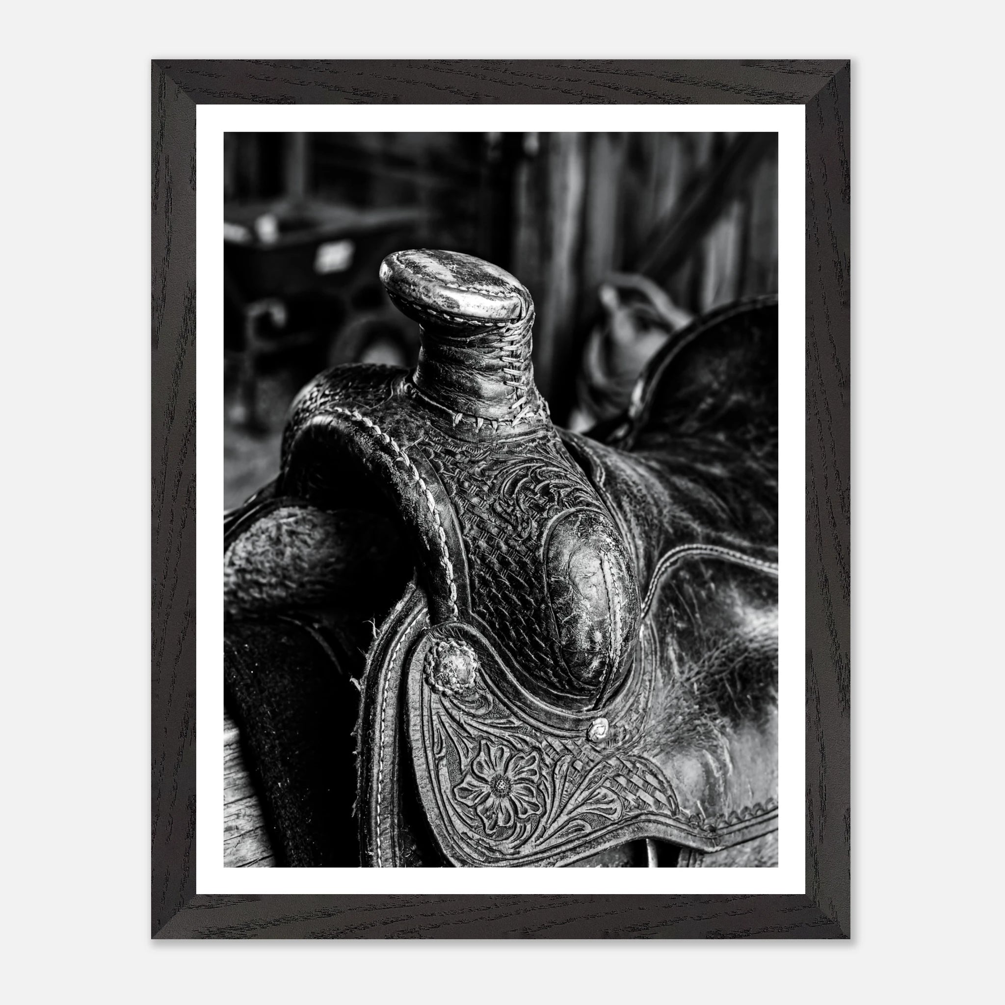 Black and white close up of a western saddle with worn leather and detailed craftsmanship, ranch wall art.