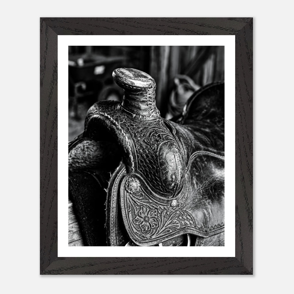 Black and white close up of a western saddle with worn leather and detailed craftsmanship, ranch wall art.