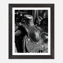 Black and white close up of a western saddle with worn leather and detailed craftsmanship, ranch wall art.