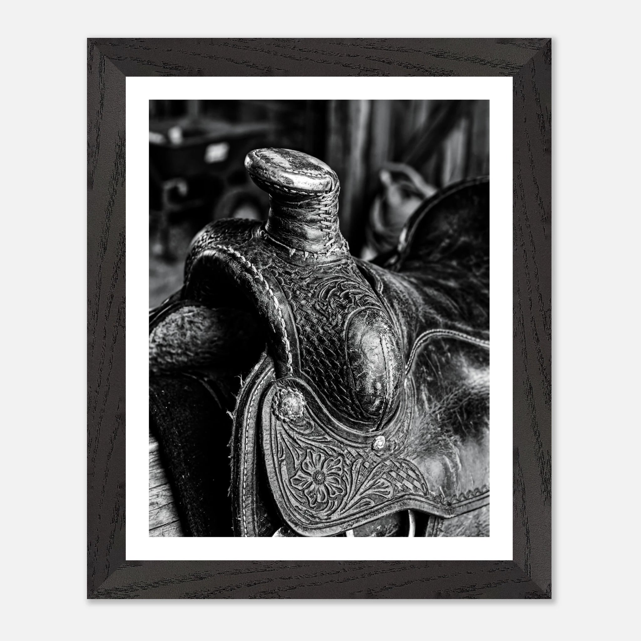 Black and white close up of a western saddle with worn leather and detailed craftsmanship, ranch wall art.